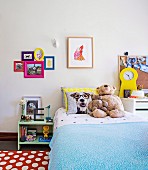 Girls room with pictures, cuddly toys and yellow table clock