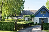 Renovated farmhouse with drive and green hedge