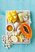 Gelbes Superfood, darunter Mango, Bananen, Papaya, Ingwer, Kurkuma, Zitronen, Cashews