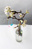 Spring arrangement: paper hearts hung from branch of blossom