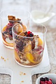 Yoghurt dessert with peaches, berries, biscuits and syrup