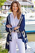 A young brunette woman wearing a white blouse and a blue-and-white cardigan