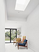 Blue and yellow, 50s retro armchairs with wooden frames against white brick wall in modern interior