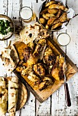 Masala roast chicken served with unleavened bread and potato wedges