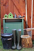 Cabinet and various gardening utensils outside wooden shed