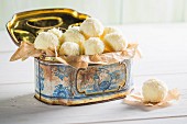 White coconut pralines in a metal tin