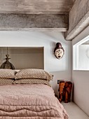 Ethnic art next to bed in bedroom with ribbon window