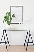 Houseplant, candlestick and Panton lamp on delicate console table made from trestles and glass panel