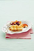 Sponge cake slices with whipped cream, plums and honey