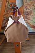 Light brown, hand-sewn, boiled-wool rucksack hanging from blackboard crank handle