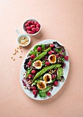 Mixed leaf salad with avocado, raspberries, goat's cheese and pine nuts