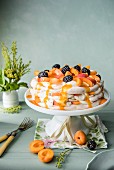 Aprikosen-Pavlova mit Brombeeren und Aprikosensauce auf Kuchenständer