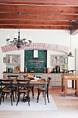 Country-house-style kitchen counter and dining area in open-plan kitchen with wood-beamed ceiling
