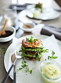A potato burger with avocado and rocket on a plate