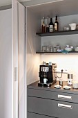 Offene Schiebetür und Blick auf Küchenschrank mit Espressomaschine