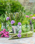 Green asparagus and fresh herbs on a garden table