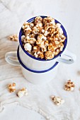 Caramel popcorn in an enamel mug