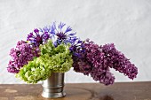 Pewter vase of lilac, hydrangeas and cornflowers