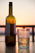 Weißwein in einem Kristallglas bei Sonnenuntergang