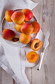 An arrangement of apricots with a halved apricot and an apricot stone