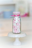 Pink and white peppermint hearts in a small glass bottle