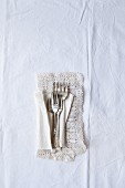 Four vintage silver cake forks on a lace doily