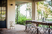 Mediterrane Terrasse mit großem Tisch und Blick in den Garten