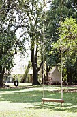 Swing in garden with mature trees