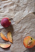 Fresh peaches, whole, halved and sliced (seen from above)