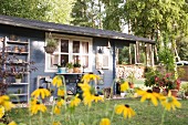 Gartenhaus im Sommer, Blumen im Vordergrund