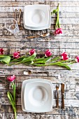 Two place settings on table decorated with tulips