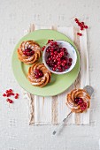 Mini wreath cakes with fresh redcurrants (seen from above)