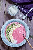 A vegan raspberry smoothie bowl with kiwi and banana slices (seen from above)