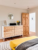 White chest of drawers with wooden drawer fronts in bedroom