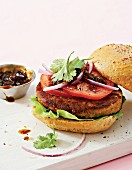 A bobotie & lentil burger with tomato and onion