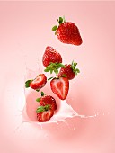 Strawberries falling into strawberry milk