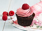 A chocolate cupcake with raspberry cream