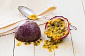 A halved passion fruit with a teaspoon