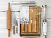 Kitchen utensils: a rolling pin, knives, cutlery, a pastry brush and a hand blender