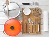 Kitchen utensils: pots, cutlery, a measuring jug, a grater and kitchen paper