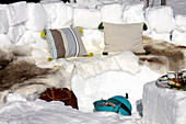Winter-Picknick mit Sitzbank aus Schnee und Fellen