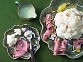 Cooked cauliflower with roast beef and herb sauce