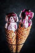 Strawberry ice-cream with blueberry compote in ice cream cones