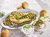 Marinated grilled courgettes with a sheep's cheese sauce and bread rolls