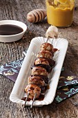 A sausage kebab with dates and a honey mustard sauce