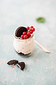 Käsekuchen mit Schokokeksen und roten Johannisbeeren im Glas