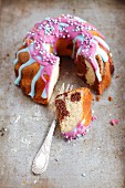 Marble cake with colourful icing and sugar sprinkles