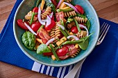 Pasta salad with tomatoes, spinach and bacon