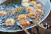 Sesame seed balls with a sweet mungo bean filling being fried