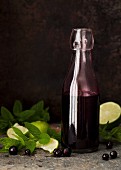 A bottle of blackcurrant syrup with lime and mint